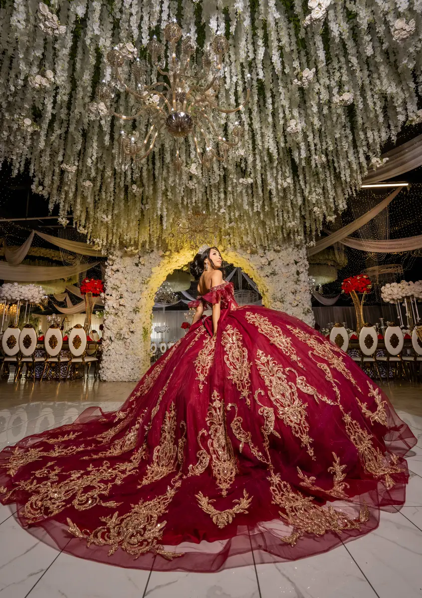 Red and gold gown beneath a floral ceiling