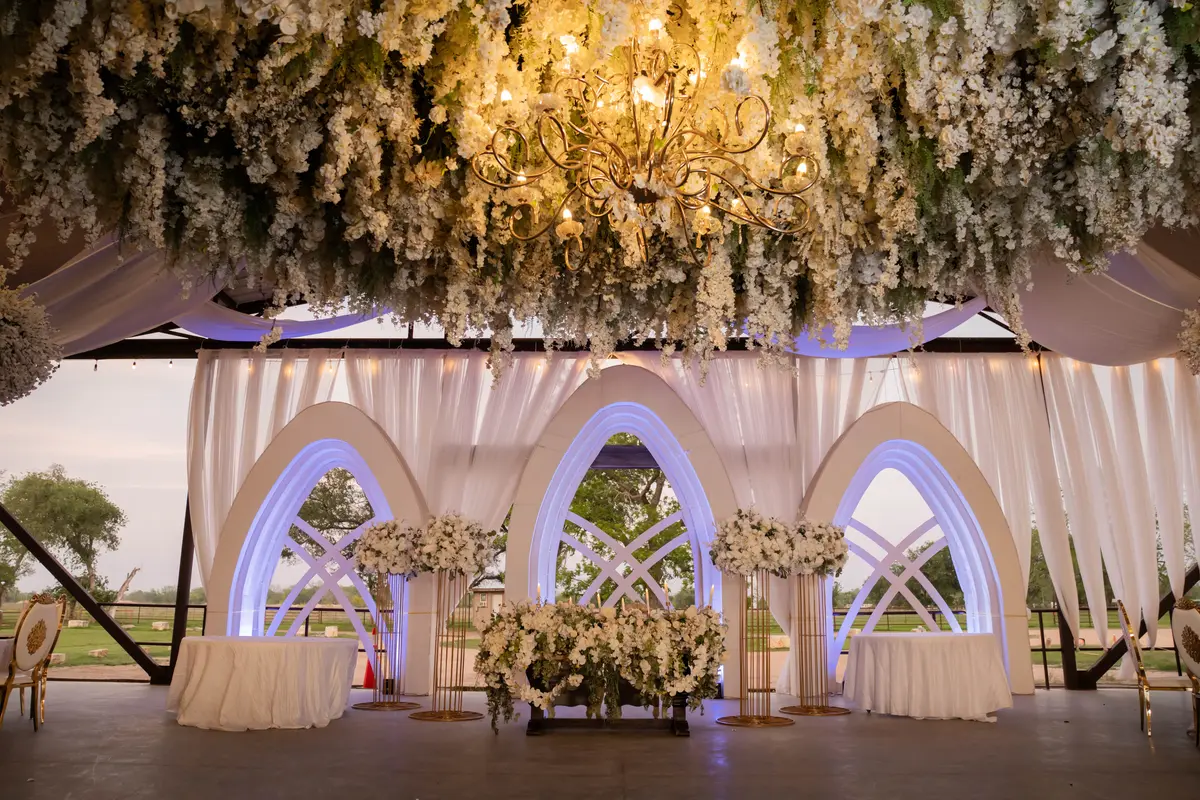 Arched head table under floral chandeliers